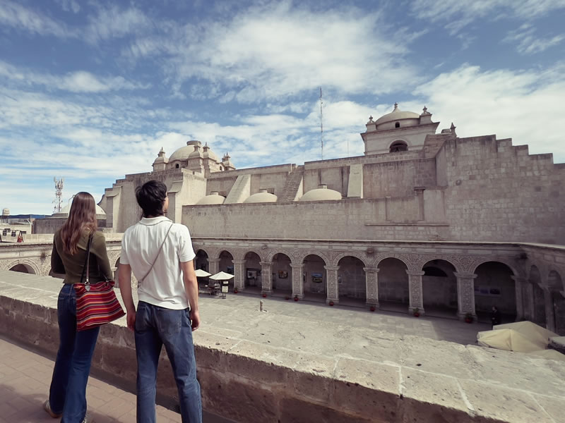 Pareja frente a un claustro de sillar en Arequipa